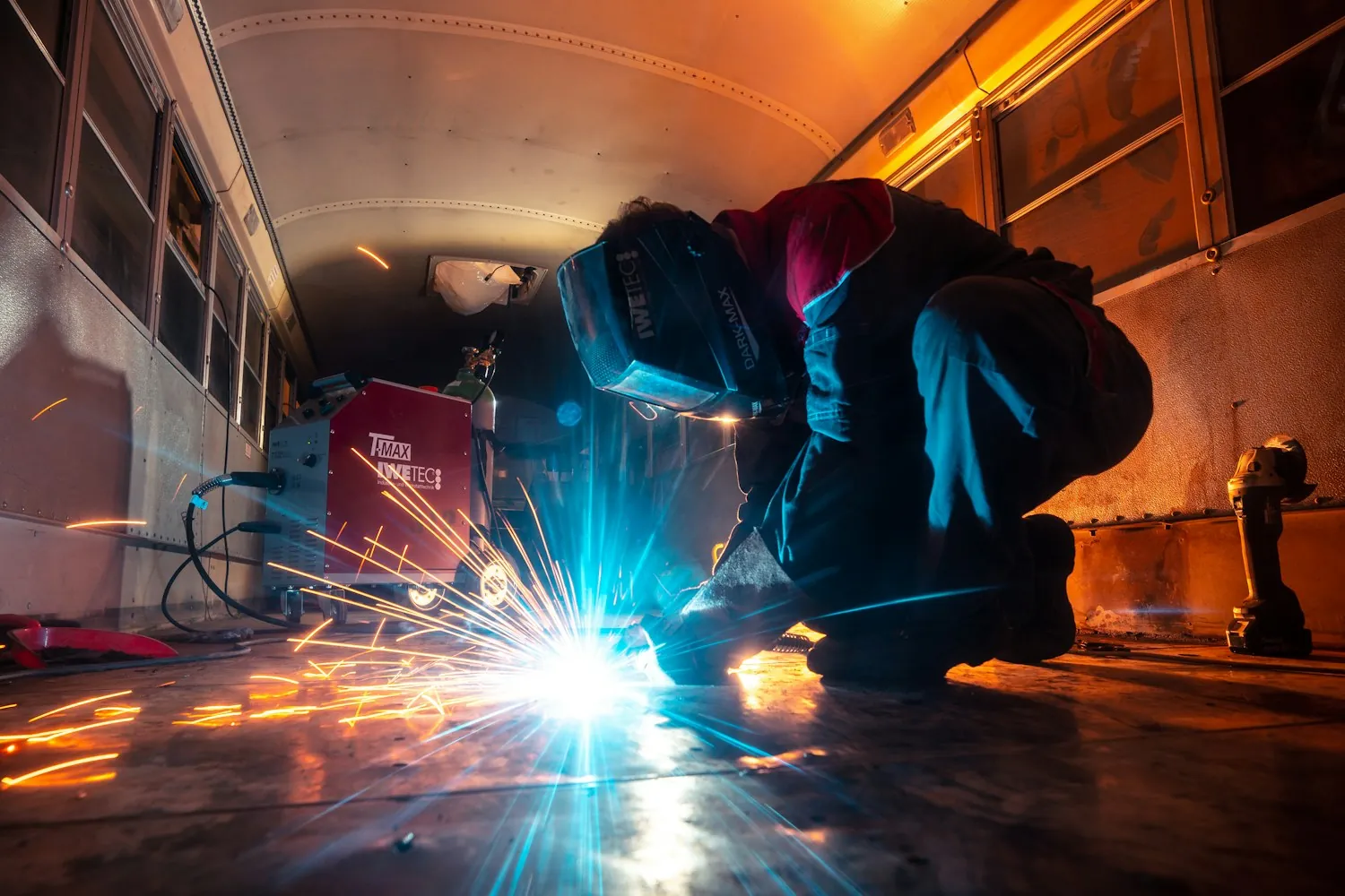 Welder working inside the shop at dusk