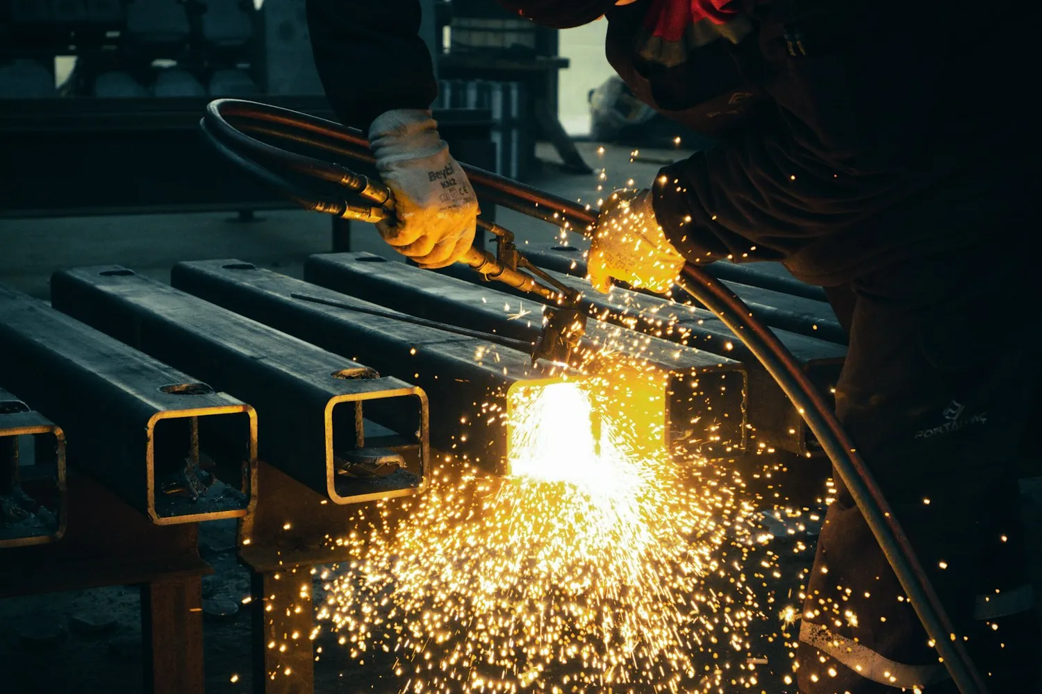 Torch cutting square steel tubing, sparks falling